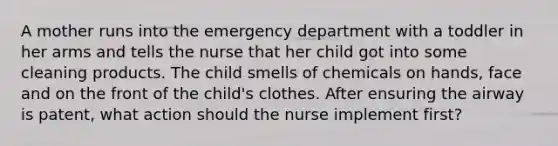 A mother runs into the emergency department with a toddler in her arms and tells the nurse that her child got into some cleaning products. The child smells of chemicals on hands, face and on the front of the child's clothes. After ensuring the airway is patent, what action should the nurse implement first?