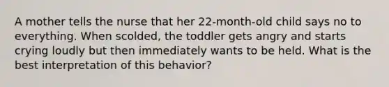 A mother tells the nurse that her 22-month-old child says no to everything. When scolded, the toddler gets angry and starts crying loudly but then immediately wants to be held. What is the best interpretation of this behavior?