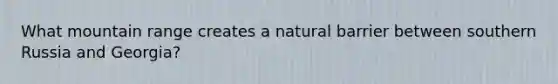What mountain range creates a natural barrier between southern Russia and Georgia?