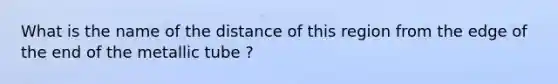 What is the name of the distance of this region from the edge of the end of the metallic tube ?