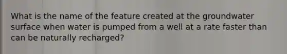 What is the name of the feature created at the groundwater surface when water is pumped from a well at a rate faster than can be naturally recharged?