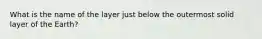 What is the name of the layer just below the outermost solid layer of the Earth?