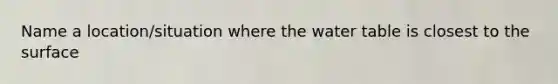 Name a location/situation where the water table is closest to the surface