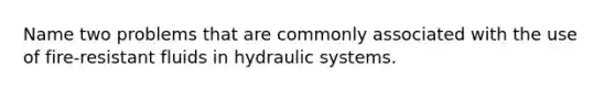 Name two problems that are commonly associated with the use of fire-resistant fluids in hydraulic systems.