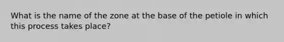 What is the name of the zone at the base of the petiole in which this process takes place?