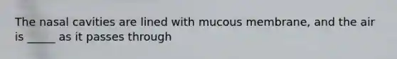 The nasal cavities are lined with mucous membrane, and the air is _____ as it passes through