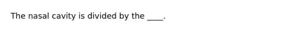 The nasal cavity is divided by the ____.