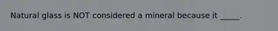 Natural glass is NOT considered a mineral because it _____.
