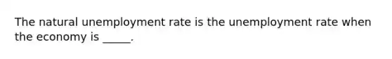 The natural unemployment rate is the unemployment rate when the economy is​ _____.