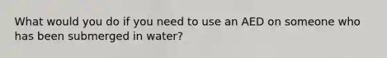 What would you do if you need to use an AED on someone who has been submerged in water?