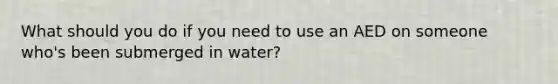 What should you do if you need to use an AED on someone who's been submerged in water?