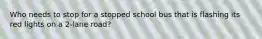 Who needs to stop for a stopped school bus that is flashing its red lights on a 2-lane road?