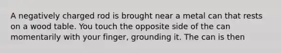 A negatively charged rod is brought near a metal can that rests on a wood table. You touch the opposite side of the can momentarily with your finger, grounding it. The can is then