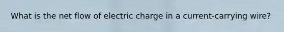 What is the net flow of electric charge in a current-carrying wire?