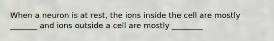 When a neuron is at rest, the ions inside the cell are mostly _______ and ions outside a cell are mostly ________