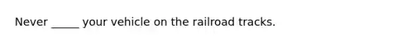 Never _____ your vehicle on the railroad tracks.