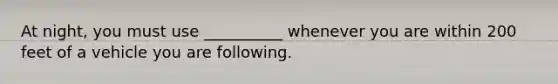 At night, you must use __________ whenever you are within 200 feet of a vehicle you are following.