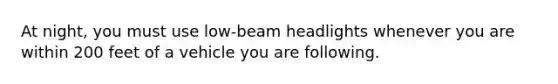 At night, you must use low-beam headlights whenever you are within 200 feet of a vehicle you are following.