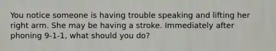 You notice someone is having trouble speaking and lifting her right arm. She may be having a stroke. Immediately after phoning 9-1-1, what should you do?