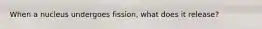 When a nucleus undergoes fission, what does it release?