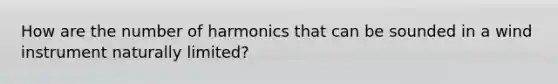 How are the number of harmonics that can be sounded in a wind instrument naturally limited?