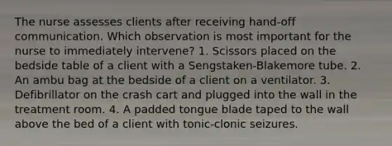 The nurse assesses clients after receiving hand-off communication. Which observation is most important for the nurse to immediately intervene? 1. Scissors placed on the bedside table of a client with a Sengstaken-Blakemore tube. 2. An ambu bag at the bedside of a client on a ventilator. 3. Defibrillator on the crash cart and plugged into the wall in the treatment room. 4. A padded tongue blade taped to the wall above the bed of a client with tonic-clonic seizures.