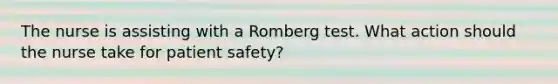 The nurse is assisting with a Romberg test. What action should the nurse take for patient safety?