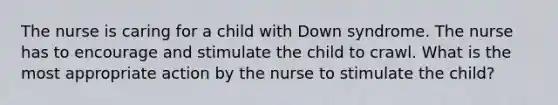 The nurse is caring for a child with Down syndrome. The nurse has to encourage and stimulate the child to crawl. What is the most appropriate action by the nurse to stimulate the child?