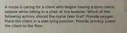 A nurse is caring for a client who begins having a tonic-clonic seizure while sitting in a chair at the bedside. Which of the following actions should the nurse take first? Provide oxygen. Place the client in a side-lying position. Provide privacy. Lower the client to the floor.