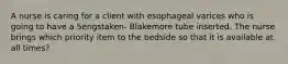 A nurse is caring for a client with esophageal varices who is going to have a Sengstaken- Blakemore tube inserted. The nurse brings which priority item to the bedside so that it is available at all times?