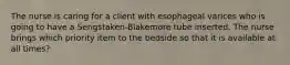 The nurse is caring for a client with esophageal varices who is going to have a Sengstaken-Blakemore tube inserted. The nurse brings which priority item to the bedside so that it is available at all times?