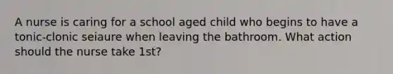 A nurse is caring for a school aged child who begins to have a tonic-clonic seiaure when leaving the bathroom. What action should the nurse take 1st?