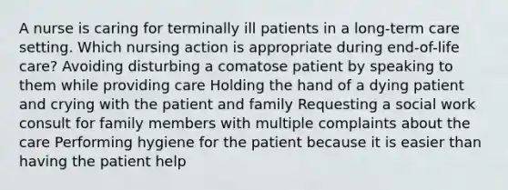 A nurse is caring for terminally ill patients in a long-term care setting. Which nursing action is appropriate during end-of-life care? Avoiding disturbing a comatose patient by speaking to them while providing care Holding the hand of a dying patient and crying with the patient and family Requesting a social work consult for family members with multiple complaints about the care Performing hygiene for the patient because it is easier than having the patient help