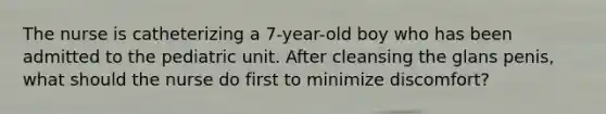 The nurse is catheterizing a 7-year-old boy who has been admitted to the pediatric unit. After cleansing the glans penis, what should the nurse do first to minimize discomfort?