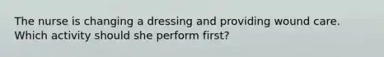 The nurse is changing a dressing and providing wound care. Which activity should she perform first?