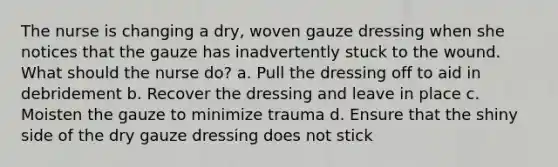 The nurse is changing a dry, woven gauze dressing when she notices that the gauze has inadvertently stuck to the wound. What should the nurse do? a. Pull the dressing off to aid in debridement b. Recover the dressing and leave in place c. Moisten the gauze to minimize trauma d. Ensure that the shiny side of the dry gauze dressing does not stick