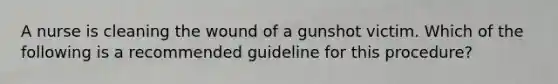 A nurse is cleaning the wound of a gunshot victim. Which of the following is a recommended guideline for this procedure?