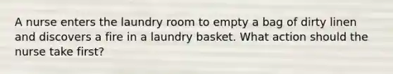 A nurse enters the laundry room to empty a bag of dirty linen and discovers a fire in a laundry basket. What action should the nurse take first?