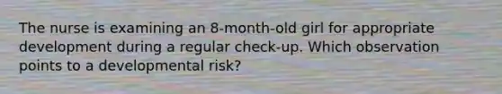 The nurse is examining an 8-month-old girl for appropriate development during a regular check-up. Which observation points to a developmental risk?