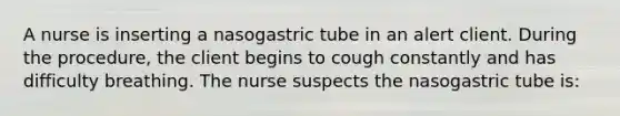 A nurse is inserting a nasogastric tube in an alert client. During the procedure, the client begins to cough constantly and has difficulty breathing. The nurse suspects the nasogastric tube is: