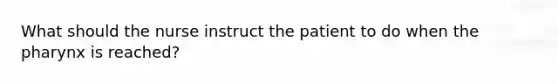 What should the nurse instruct the patient to do when the pharynx is reached?