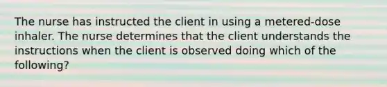 The nurse has instructed the client in using a metered-dose inhaler. The nurse determines that the client understands the instructions when the client is observed doing which of the following?