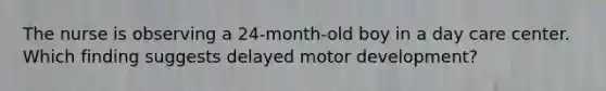 The nurse is observing a 24-month-old boy in a day care center. Which finding suggests delayed motor development?