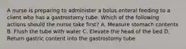 A nurse is preparing to administer a bolus enteral feeding to a client who has a gastrostomy tube. Which of the following actions should the nurse take first? A. Measure stomach contents B. Flush the tube with water C. Elevate the head of the bed D. Return gastric content into the gastrostomy tube