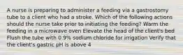 A nurse is preparing to administer a feeding via a gastrostomy tube to a client who had a stroke. Which of the following actions should the nurse take prior to initiating the feeding? Warm the feeding in a microwave oven Elevate the head of the client's bed Flush the tube with 0.9% sodium chloride for irrigation Verify that the client's gastric pH is above 4