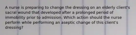 A nurse is preparing to change the dressing on an elderly client's sacral wound that developed after a prolonged period of immobility prior to admission. Which action should the nurse perform while performing an aseptic change of this client's dressing?