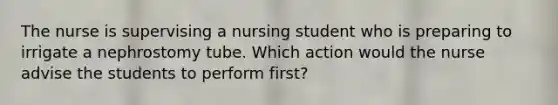 The nurse is supervising a nursing student who is preparing to irrigate a nephrostomy tube. Which action would the nurse advise the students to perform first?