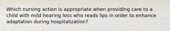 Which nursing action is appropriate when providing care to a child with mild hearing loss who reads lips in order to enhance adaptation during hospitalization?