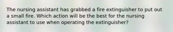 The nursing assistant has grabbed a fire extinguisher to put out a small fire. Which action will be the best for the nursing assistant to use when operating the extinguisher?