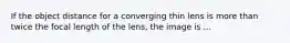 If the object distance for a converging thin lens is more than twice the focal length of the lens, the image is ...